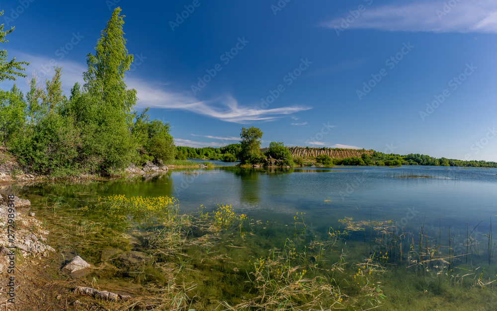 Sunny summer day at an abandoned quarry for the extraction of stone.