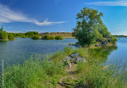 Sunny summer day at an abandoned quarry for the extraction of stone.