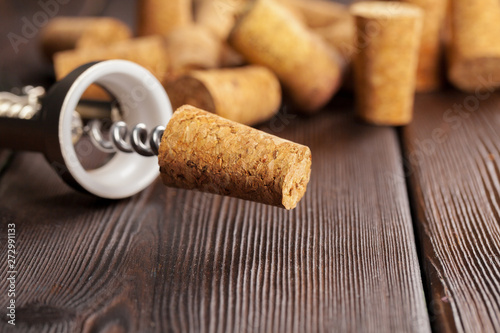 Wine corks with corkscrew on wooden table