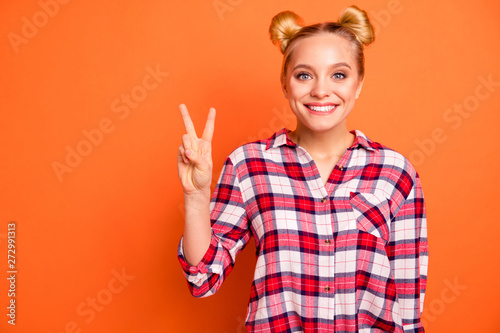 Portrait of lovely sweet millennial she her make v-sign enjoy feel rejoice dressed checked shirt plaid isolated orange background 