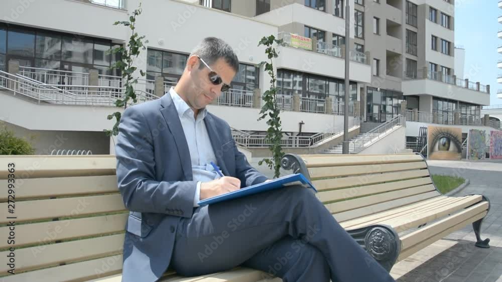 business man takes notes on a city street business man takes notes on a city street