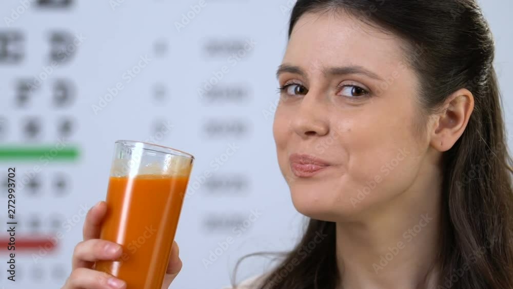 Female drinking delicious carrot juice, supplement for vision health, nutrition Female drinking delicious carrot juice, supplement for vision health, nutrition