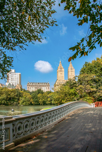 New York City, NY / USA - October 7th, 2007: The Bow Bridge at Central Park with a rowing boat in the lake and Dakota Building in the distance