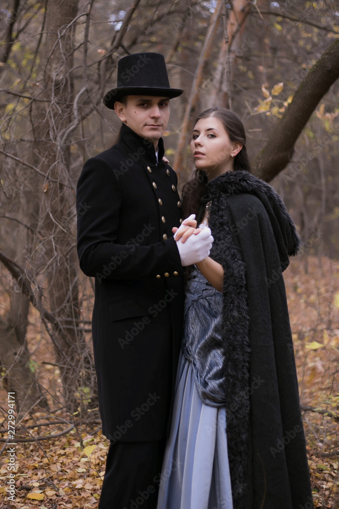 Woman and man in nineteenth century clothes in a gloomy forest