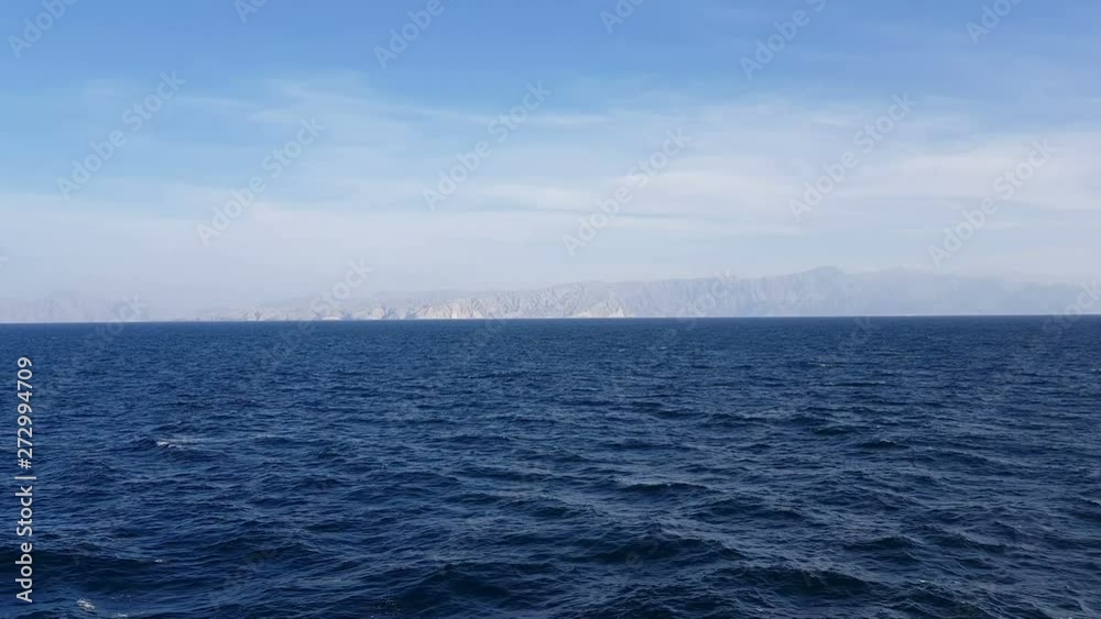 View of the ocean and clouds in the sky. Blue sky with clouds in sunny weather over the ocean. Mountains and ocean on the horizon. View of the ocean and clouds in the sky. Blue sky with clouds in sunny weather over the ocean. Mountains and ocean on the horizon.