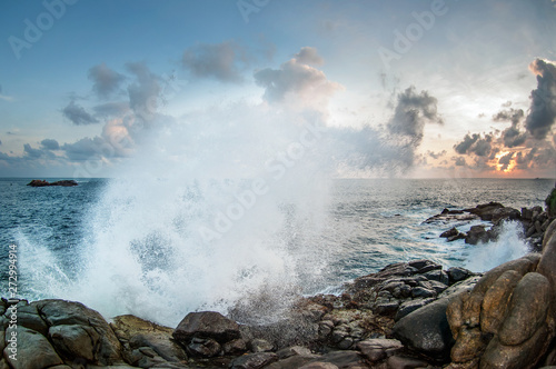 The waves break on the rocks at sunset.
