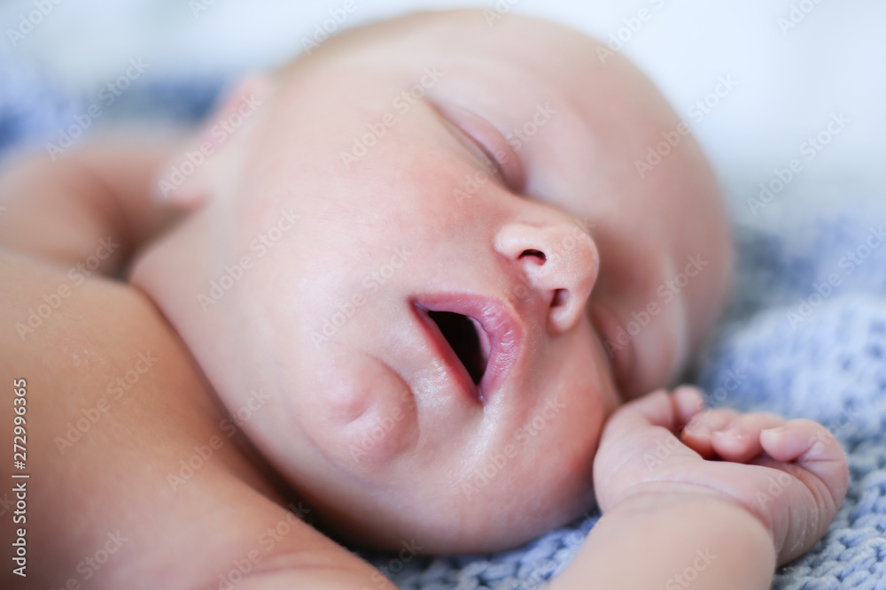 Newborn baby boy sleeping in children's cot - closeup Newborn baby boy sleeping in children's cot - closeup