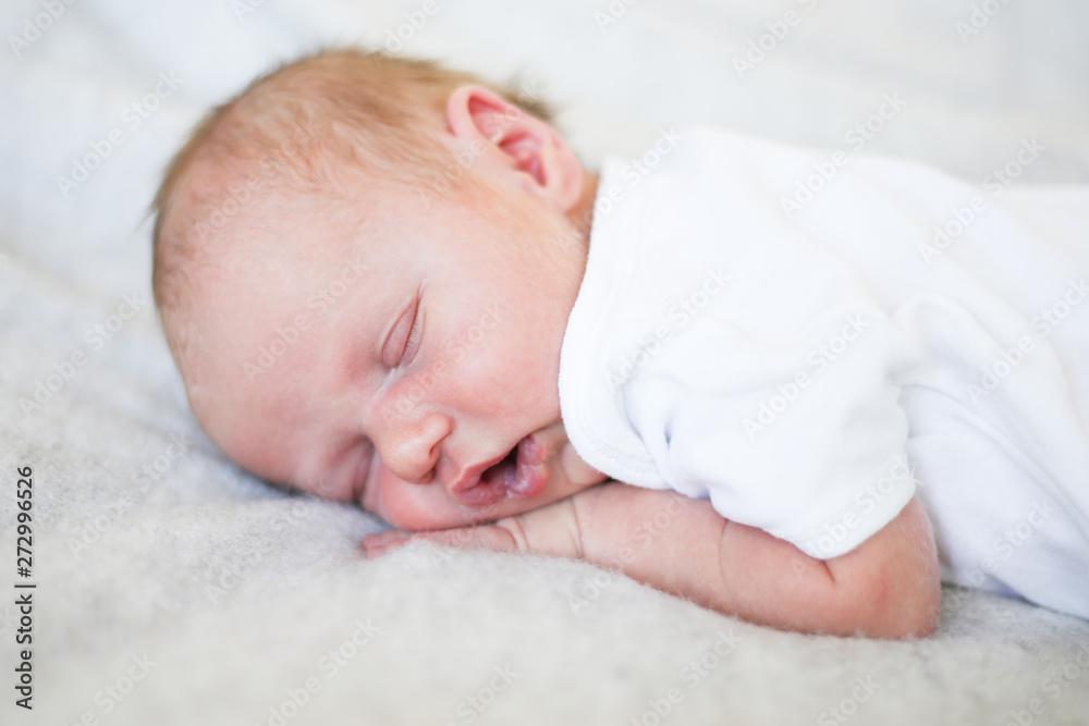 Newborn baby boy sleeping in children's cot - closeup Newborn baby boy sleeping in children's cot - closeup