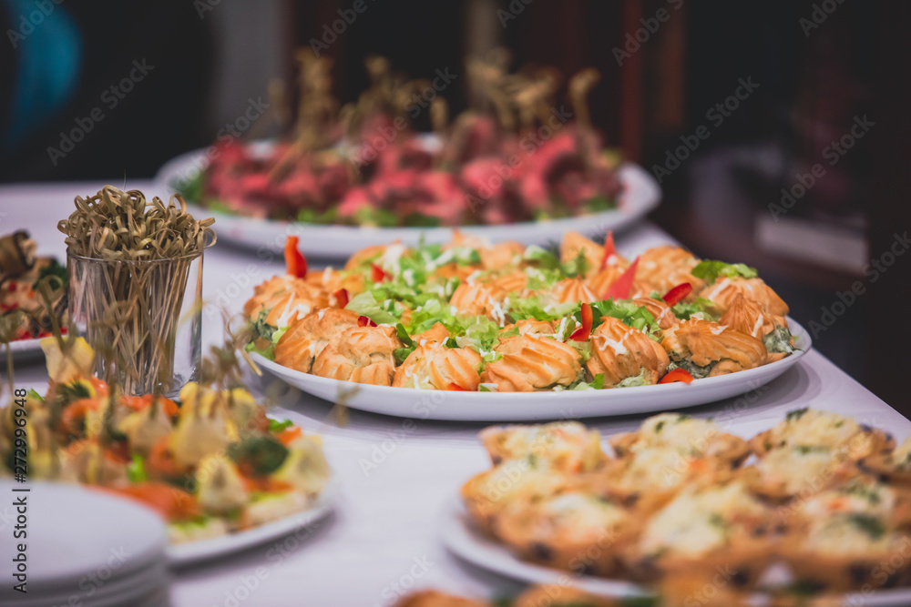 Obraz premium Beautifully decorated catering banquet table with different food snacks and appetizers on corporate, christmas, birthday party event or wedding celebration