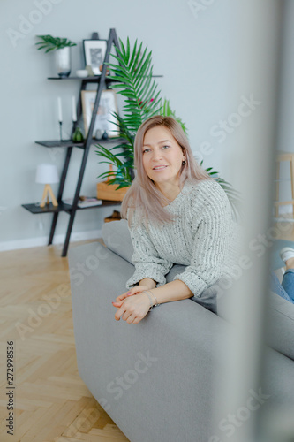 Blonde young woman in a grey wool pullover