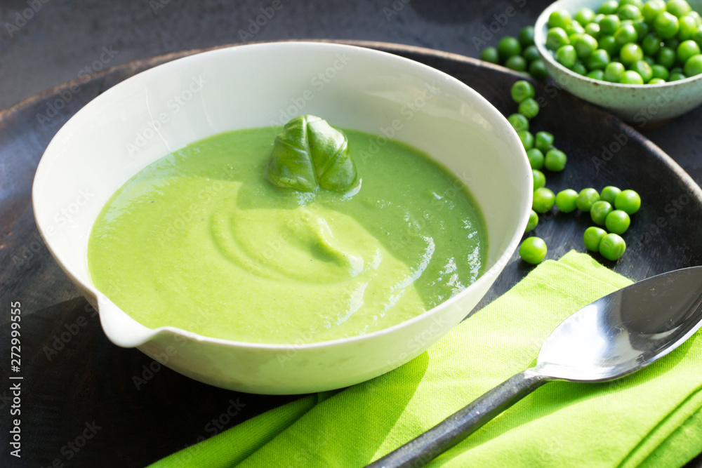 Vegane Erbsensuppe mit Basilikum in Suppenschüssel mit Löffel serviert Vegane Erbsensuppe mit Basilikum in Suppenschüssel mit Löffel serviert