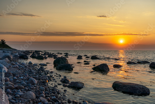 Sunset at a stony beach with cloudy horizon