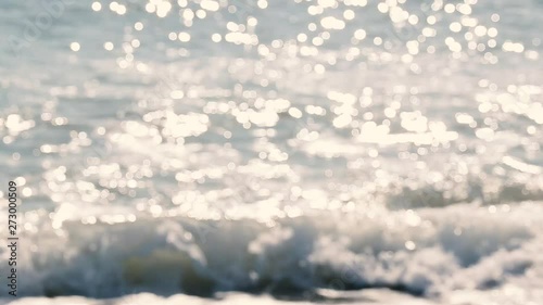 Beautiful sunny blurry sea water splashing outside at beach. Charming sparkling natural video background.