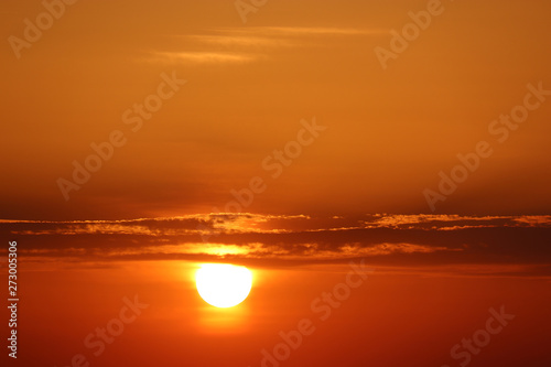 Fototapeta Naklejka Na Ścianę i Meble -  Sunset with dark clouds, setting shining sun and orange sky. Beautiful skyline for background