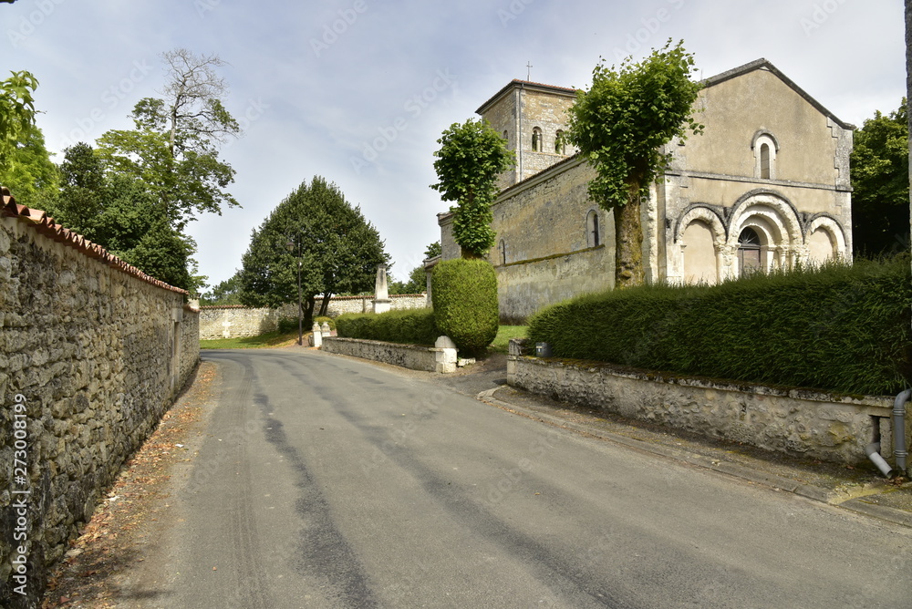 Route de campagne entre les murs d'enceinte du château et l'église de Vendoire au Périgord Vert