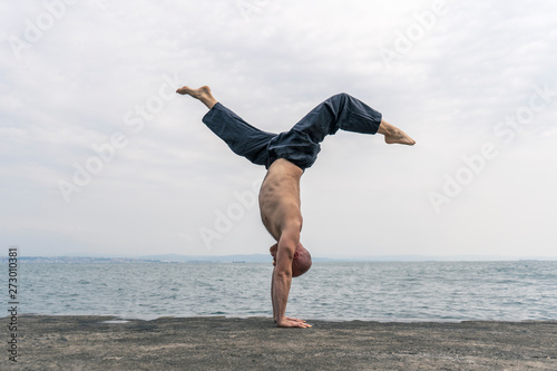 Man practicing yoga handstand outdoors