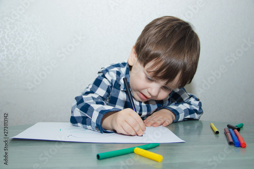 The boy draws felt-tip pens on paper. Drawing. Little boy. Children's drawing. Developmental activities.