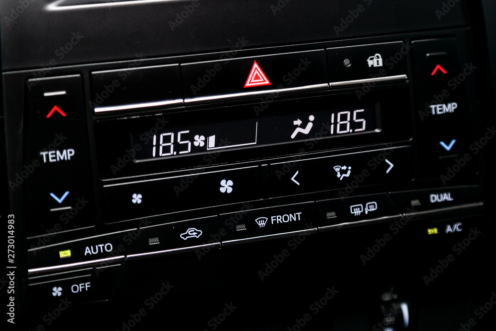 Сlose-up of the car black interior: dashboard with temperature, clock, adjustment of the blower, air conditioner and other buttons. Сlose-up of the car black interior: dashboard with temperature, clock, adjustment of the blower, air conditioner and other buttons.