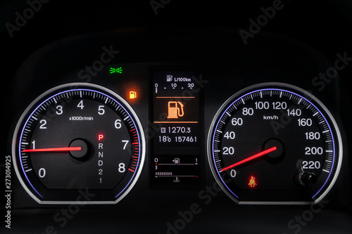 Interior view of car with black salon. Modern luxury prestige car interior: speedometer, dashboard and tachometer with white backlight and other buttons.Soft focus