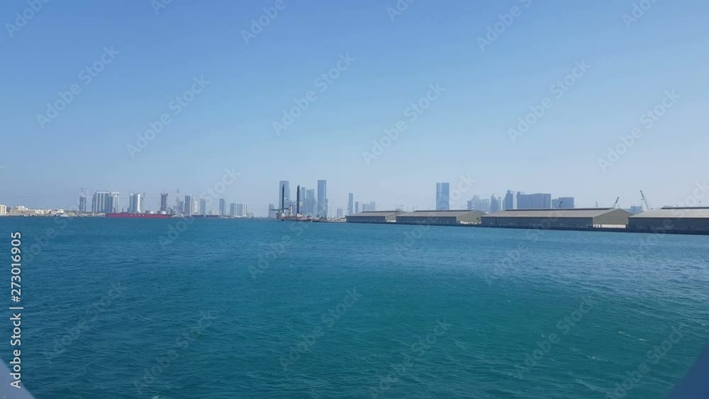 View of the sea port and blue ocean on a sunny day. View of the blue ocean through the porthole of a cruise liner.Sea port and view of the city with skyscrapers on the horizon. View of the sea port and blue ocean on a sunny day. View of the blue ocean through the porthole of a cruise liner.Sea port and view of the city with skyscrapers on the horizon.