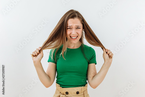 Frustrated and stress emotion. Portrait of brown hairl young woman against white background photo