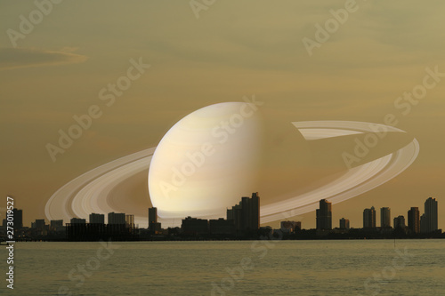 Saturn on night sky back silhouette city on sunset