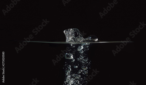 Water surface with bubbles isolated on black background. Drop of water fallen into liquid. Black background for overlays design, screen blending mode layer. Perfect for compositing into your shots