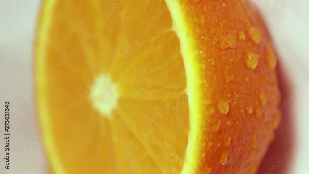 Drops of water flow down a juicy ripe orange. Fruit close-up. Orange on a white background. Drops of water flow down a juicy ripe orange. Fruit close-up. Orange on a white background.