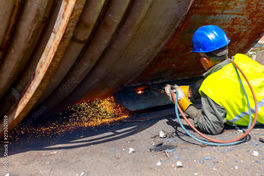 Ταπετσαρία Worker is cutting old metal industrial equipment with acetylene torch