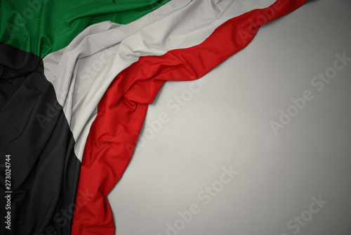 waving national flag of kuwait on a gray background.