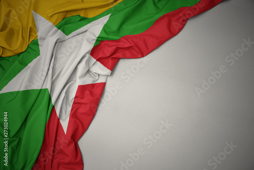 waving national flag of myanmar on a gray background.