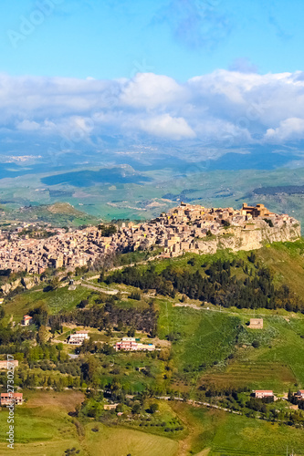 Historical Arab village Calascibetta on the top of the hills in Sicily, Italy. Taken with nearby mountains and green landscape. Photographed from Enna. Norman era fortress