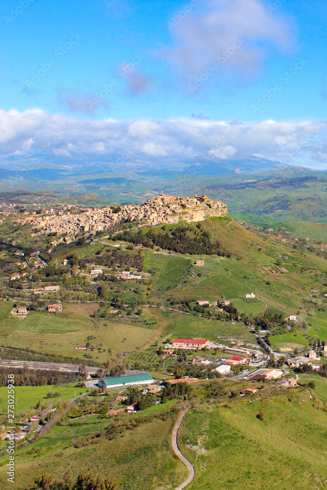 Beautiful Sicilian village Calascibetta photographed from nearby Enna with adjacent mountains and green landscape. Amazing landscapes in Italy. Italian travel destinations
