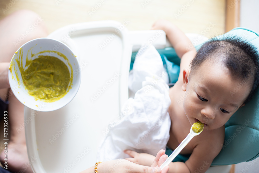 Baby boy 6 - 8 month eating crushed pumpkin with vegetable and meat Baby boy 6 - 8 month eating crushed pumpkin with vegetable and meat
