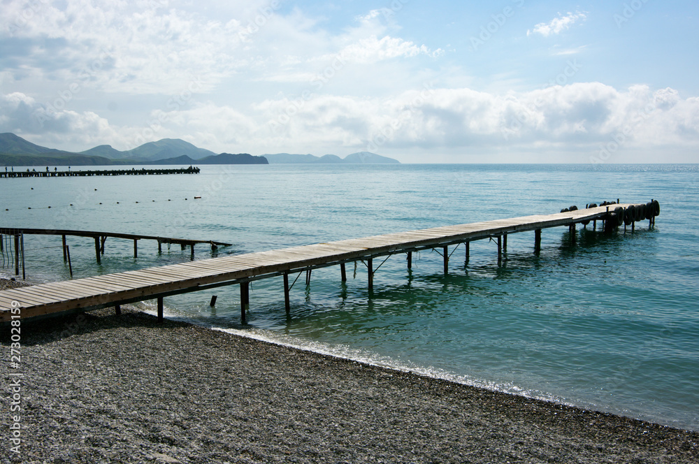 Seascape with pier and hills