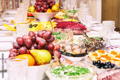 Served table. Snacks, fruits, sandwiches, salads, caviar and slicing on the holiday table. Selective focus