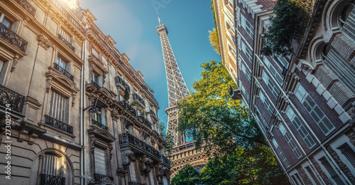 Paris street with view on the famous paris eiffel tower from rue de l'université on a sunny day with some sunshine