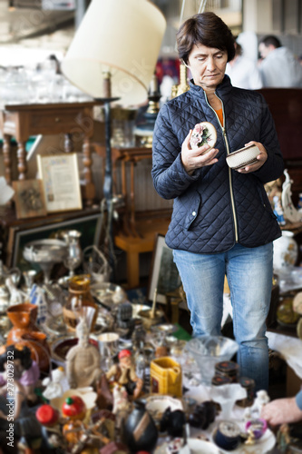 Mature woman  buying retro handicrafts on market