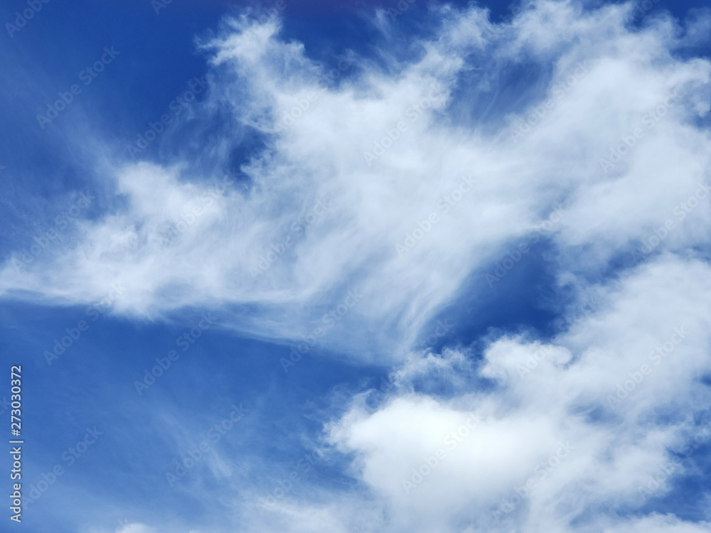 white wispy summer clouds in blue sky