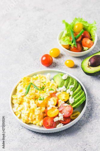 Scrambled eggs with cherry tomatoes , avocado feta cheese and olive oil.Selective focus, space for text.