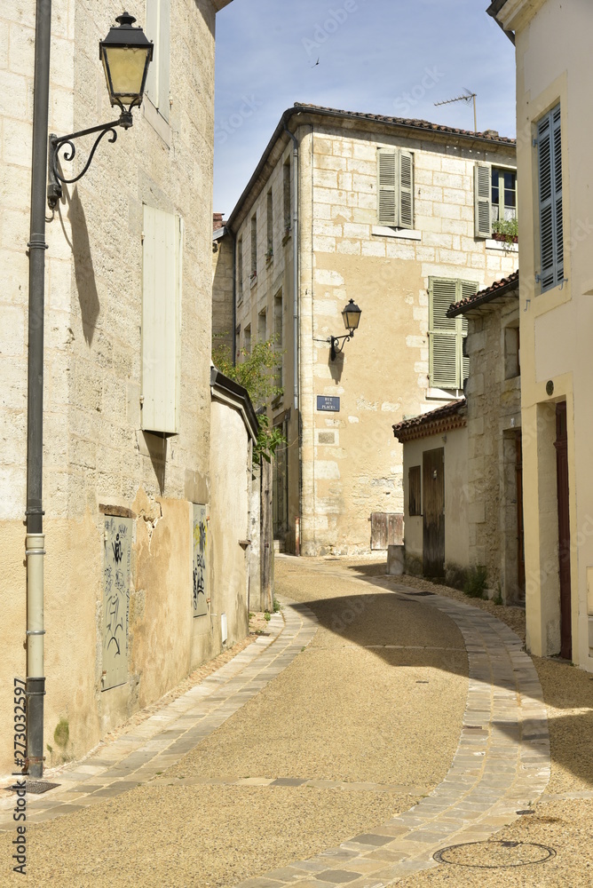 Obraz premium Rue ou ruelle typique en pente récemment restaurée entre les vieux murs du centre historique de Périgueux en Dordogne