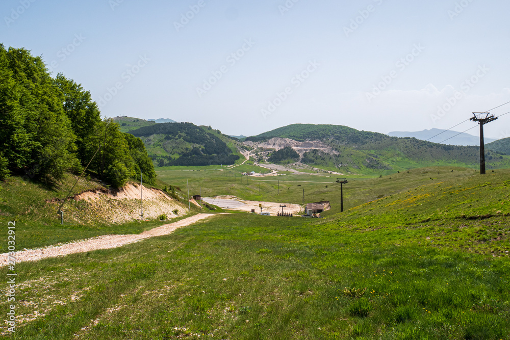 Fototapeta premium Mountains of Roccaraso with skilifts in summer, the (plateau) Piano Aremogna and Pizzalto, Monte Greco, Monti Marsicani highest group of Apennines. L'Aquila, Abruzzo, Italy