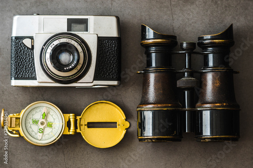 old, retro travel accessories - compass, binoculars, analogue camera, flat lay 