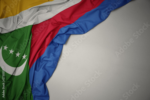 waving national flag of comoros on a gray background.