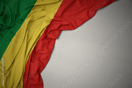 waving national flag of republic of the congo on a gray background.