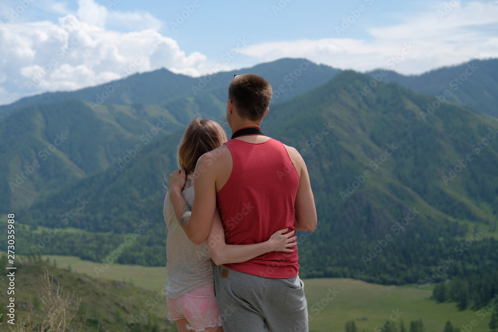 Young Caucasian boy and girl admire scenery of the mountains in front of them.