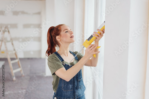 frau verteilt acryl rund um die fenster auf einer baustelle photo