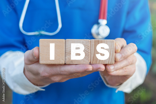 Physician holds three wooden blocks with IBS acronym. IBS Irritable Bowel Syndrome Health Care concept. photo
