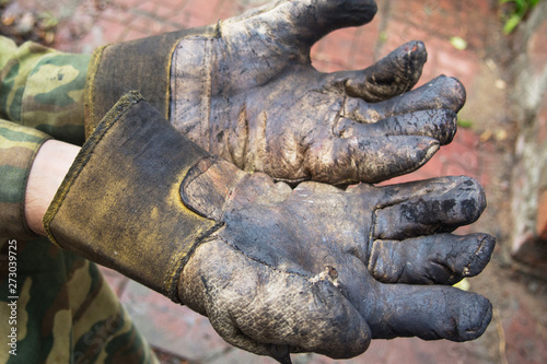 man's hands in burned leather gloves