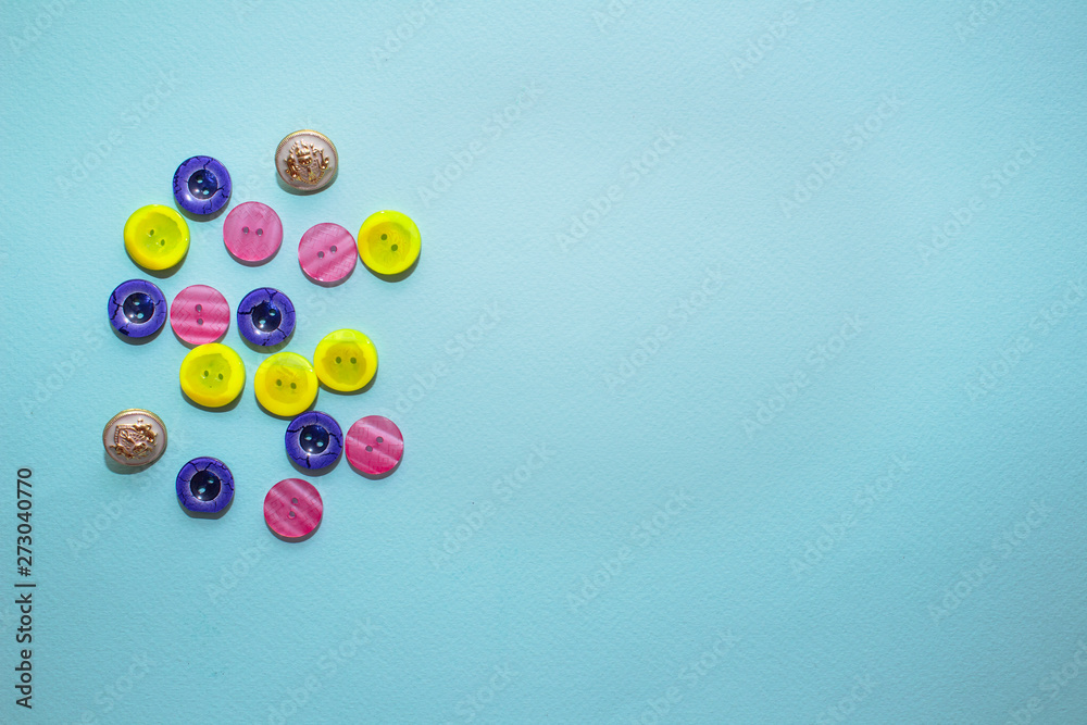 collection of various multicolored sewing button on blue background. Yellow, purple, dark blue buttons. Minimalism. Sewing accessories. Flatlay, place for text collection of various multicolored sewing button on blue background. Yellow, purple, dark blue buttons. Minimalism. Sewing accessories. Flatlay, place for text